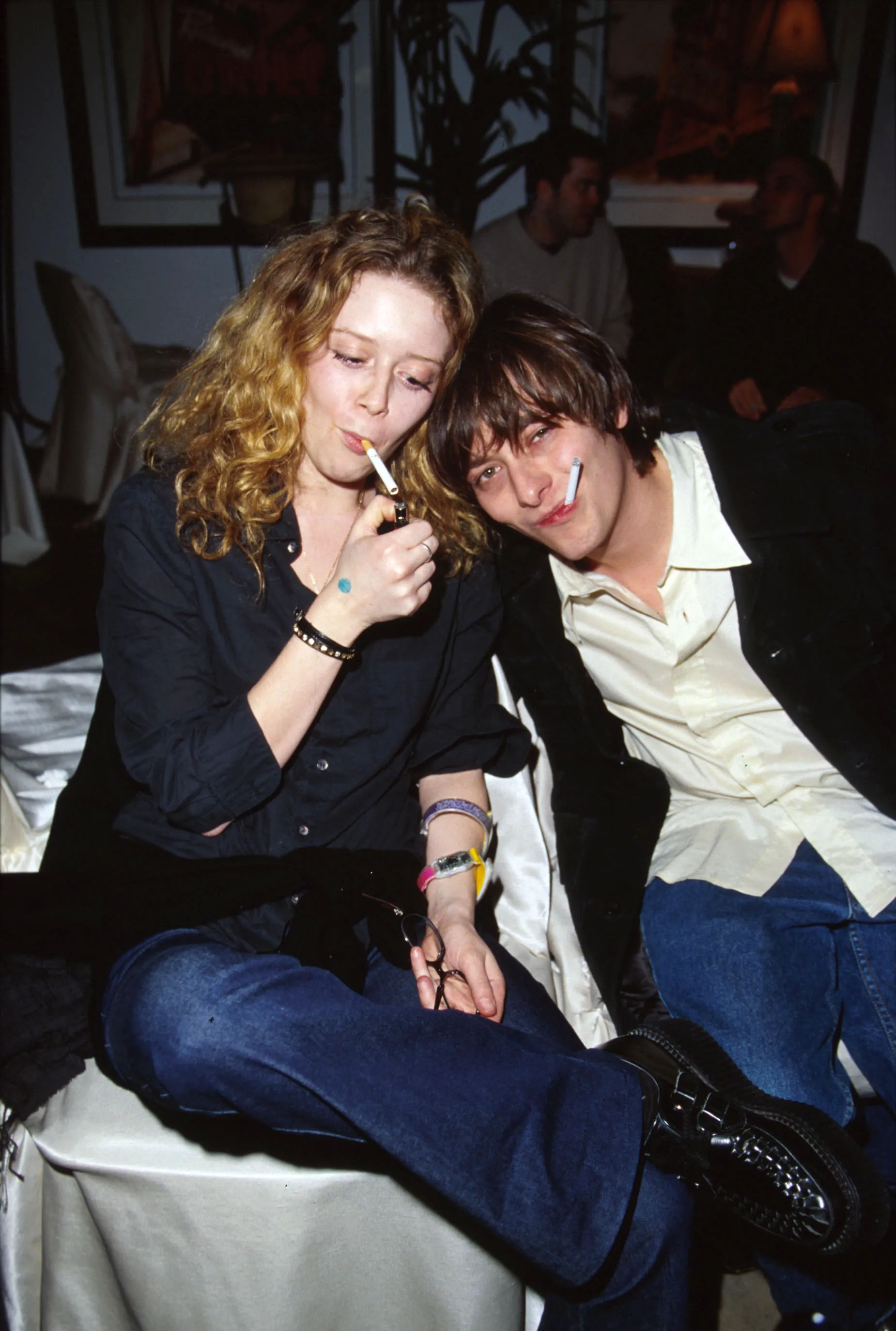 Natasha Lyonne lighting a cigarette while Edward Furlong poses with a cigarette in his mouth.