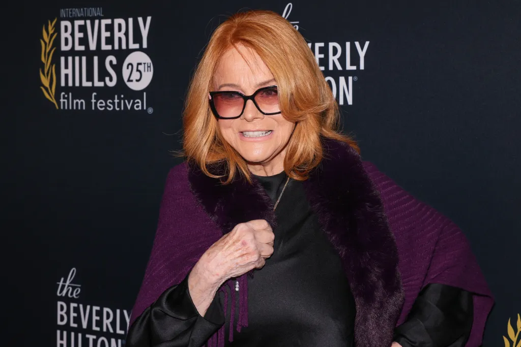Ann Margret wearing a purple wrap with fur trim and dark sunglasses at the Beverly Hills Film Festival.
