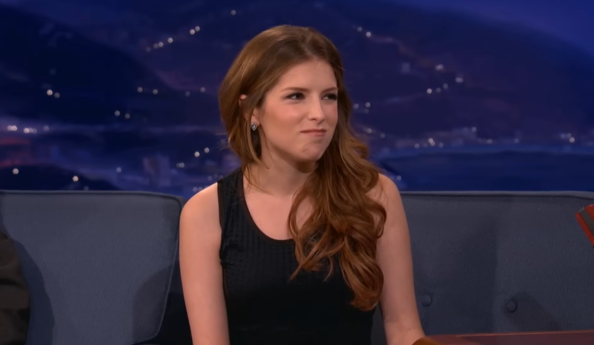Actress Anna Kendrick in a black top with an expressive face.