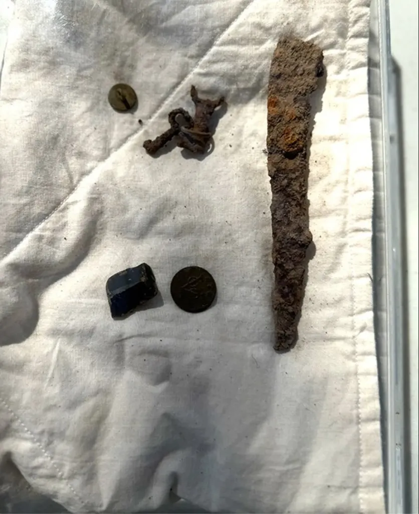 Revolutionary War era artifacts, including a small set of keys, coins, and metal objects, uncovered during an excavation.