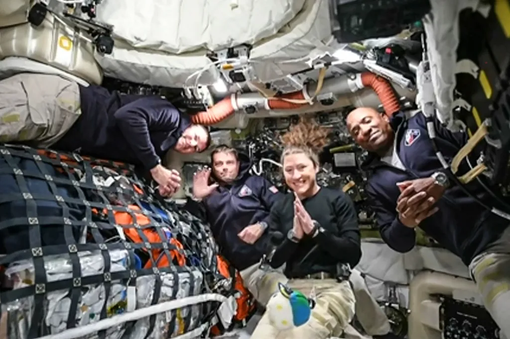 Four astronauts in the Artemis II crew pose for a photo in the spacecraft.