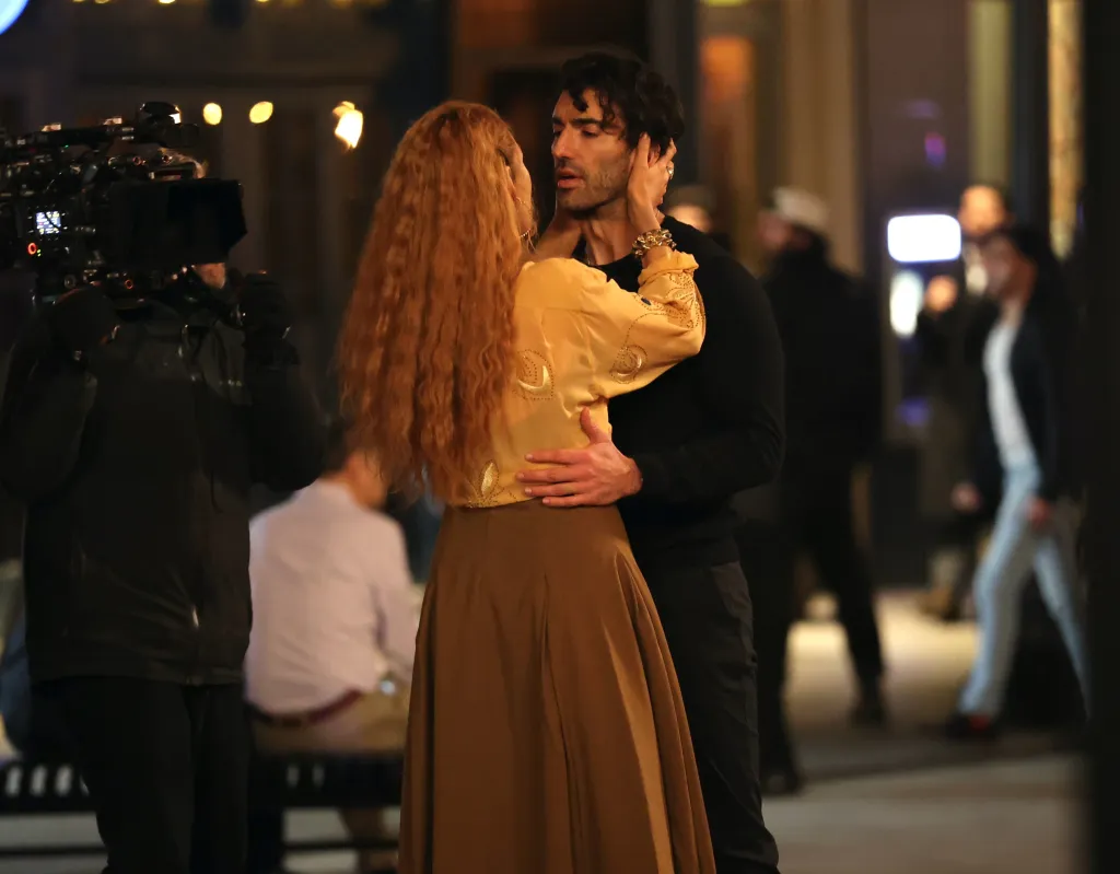 Blake Lively and Justin Baldoni embrace on the set of "It Ends with Us" with a camera crew visible to the left.