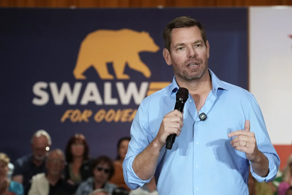 Rep. Eric Swalwell speaks into a microphone at a town hall meeting.