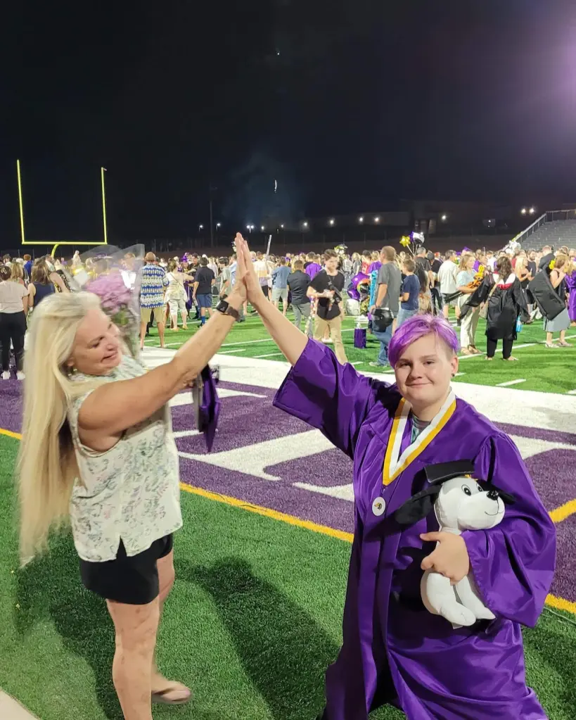 Darrell Sheets and granddaughter Zoie high-fiving at graduation.
