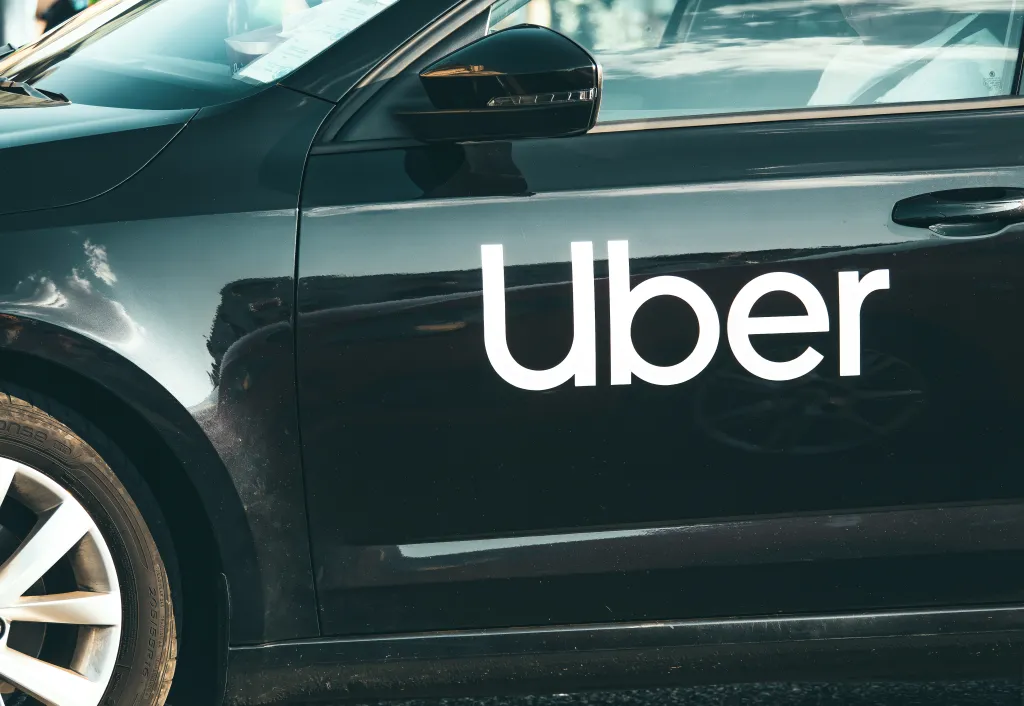 Black car with "Uber" logo in white text on the side door.