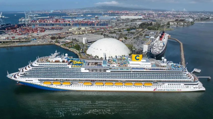 Carnival Firenze cruise ship docked at Long Beach Cruise Terminal, with the Queen Mary and industrial port in the background.