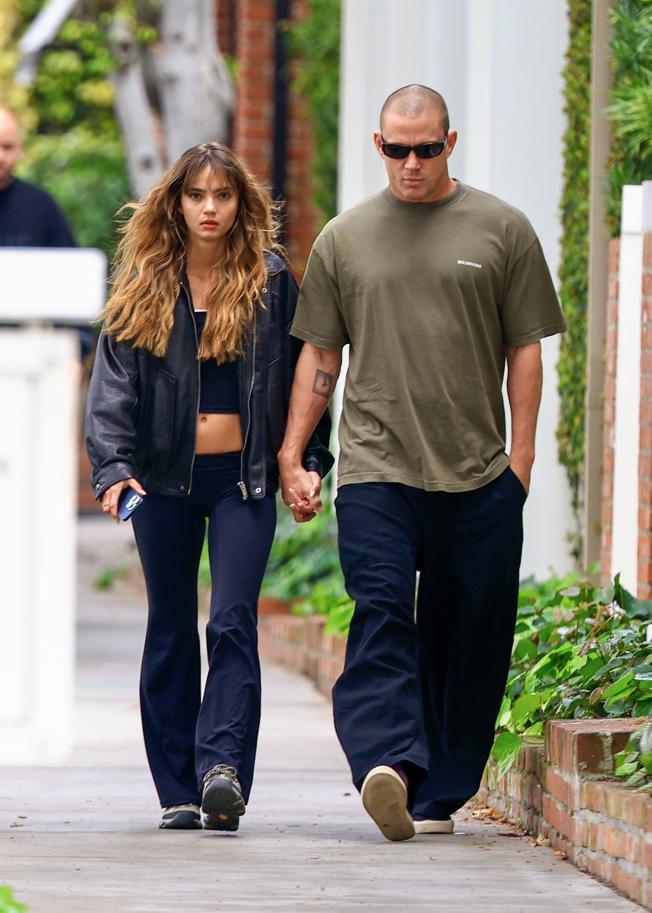 Channing Tatum and Inka Williams holding hands while walking on a sidewalk.