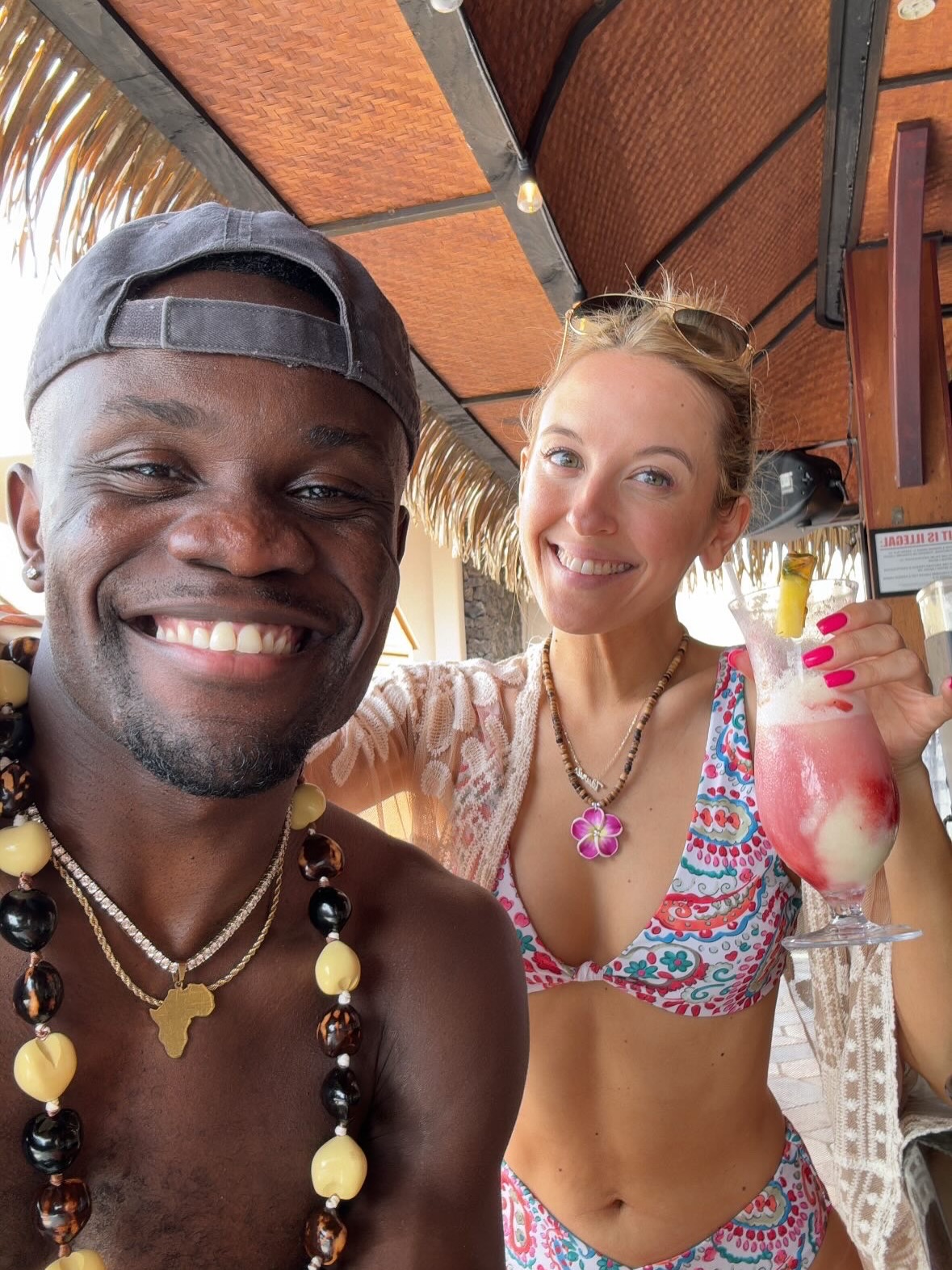 Kwame Appiah and Chelsea Griffin smiling at the camera, with Griffin holding a cocktail.