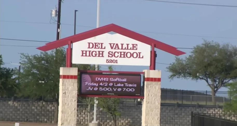 Del Valle High School sign with an electronic message board displaying "DVHS Softball Friday 4/2 @ Lake Travis JV @ 5:00; V @ 7:00".
