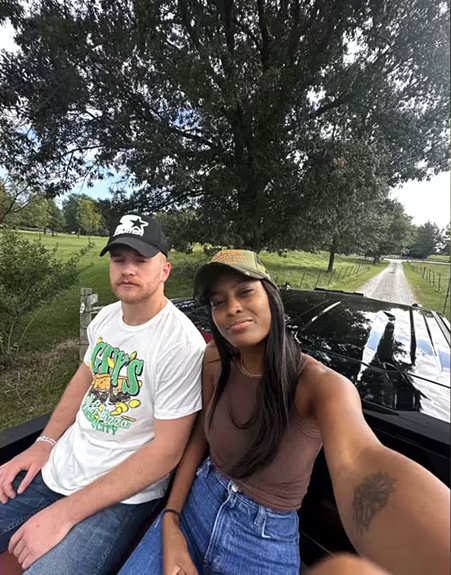 Ciara Miller and West Wilson sit in the back of a vehicle.