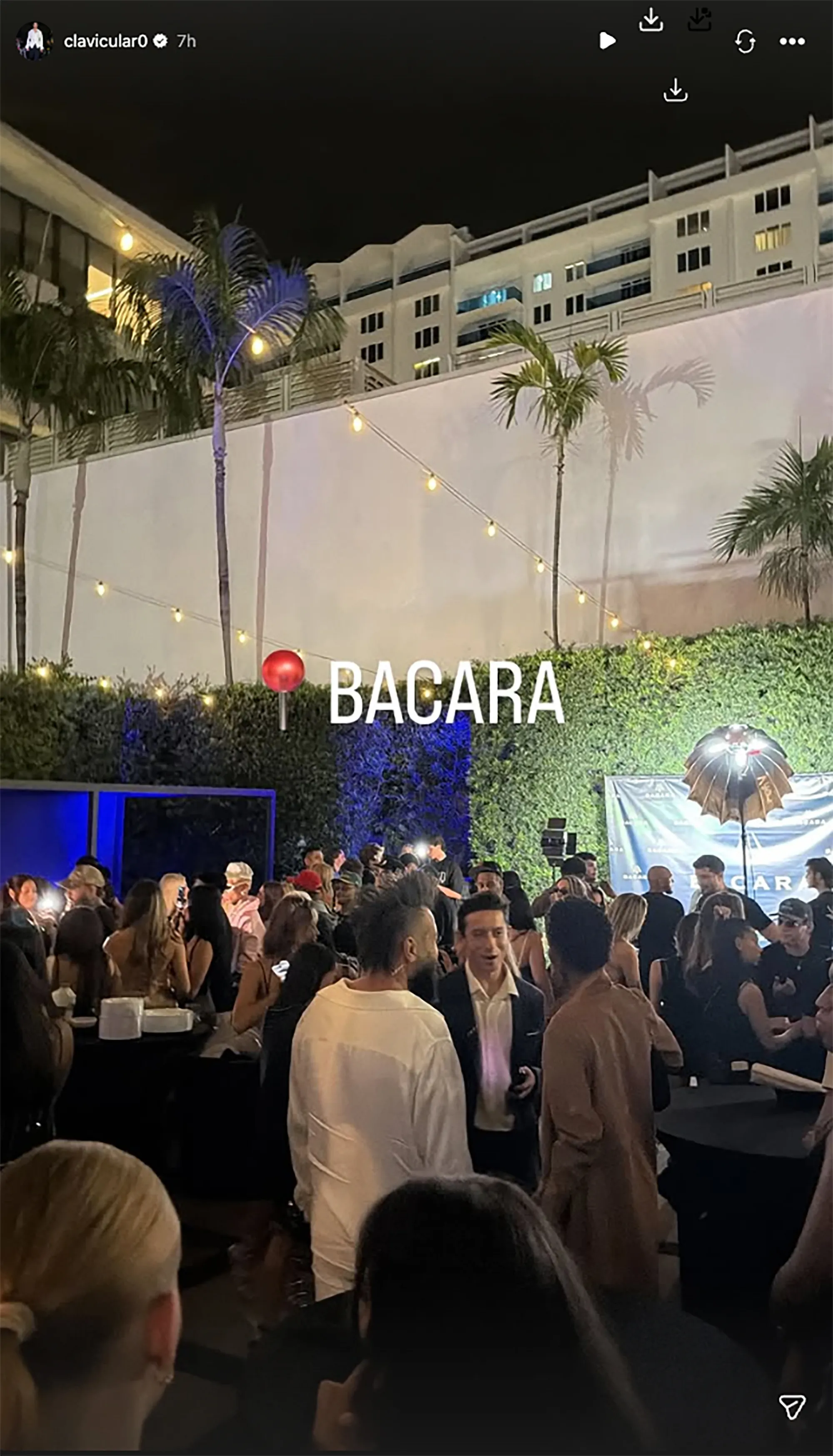 A crowded outdoor nightclub in Miami with "BACARA" projected on the wall.