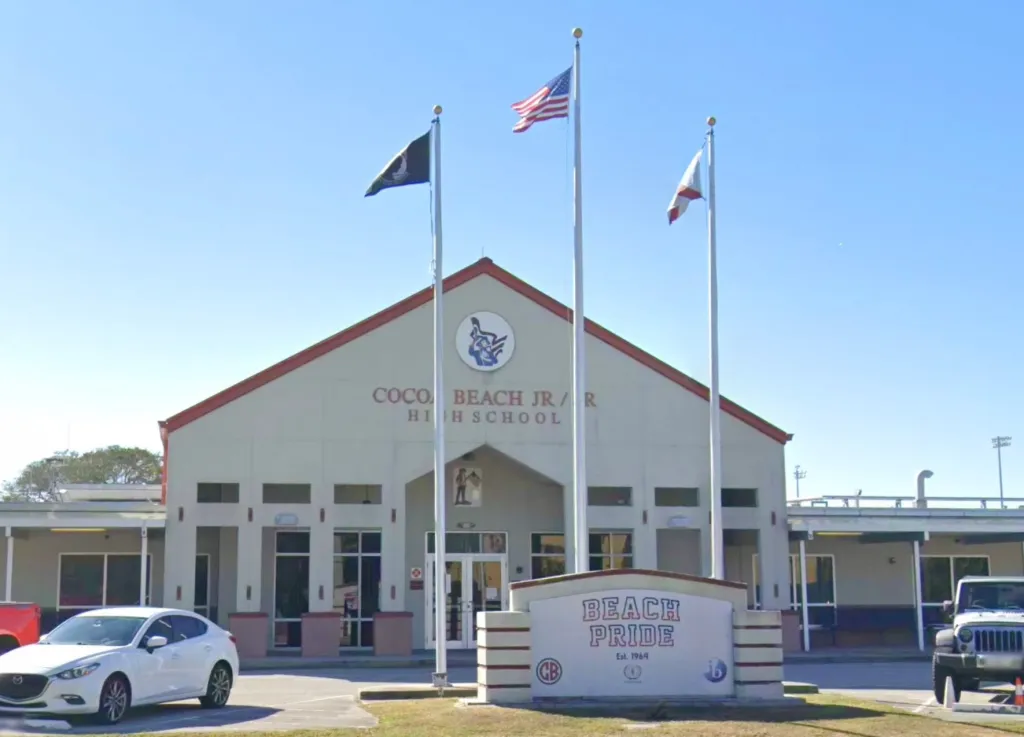 Cocoa Beach Jr./Sr. High School building entrance with a "BEACH PRIDE" sign in front.
