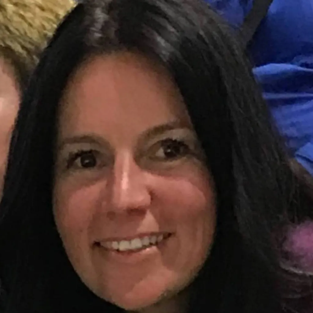 Nadia Vitels, a woman with long dark hair, smiling.