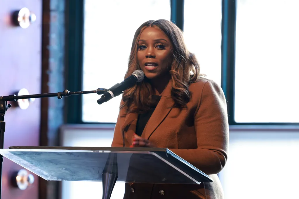 Council Member Farah Louis speaking at a podium.