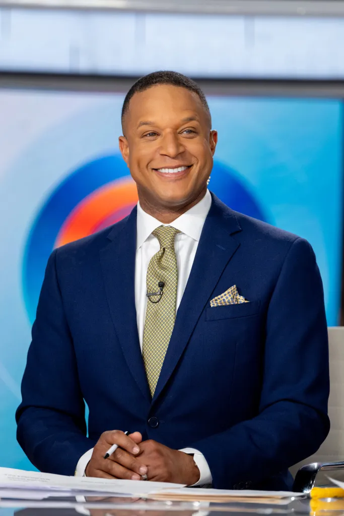 Craig Melvin smiling while wearing a blue suit and patterned tie.