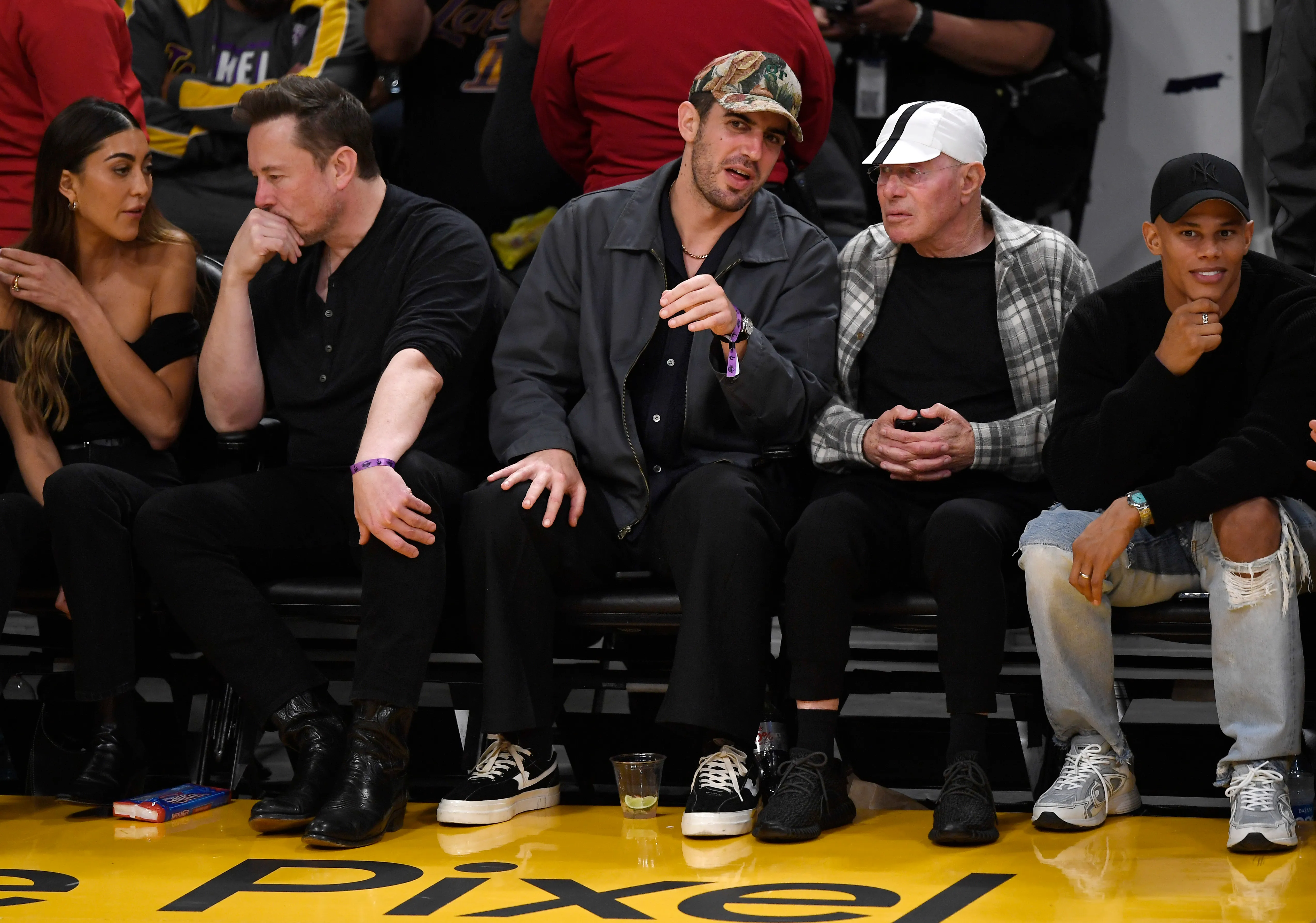 Elon Musk and David Geffen sitting courtside at a Lakers game.