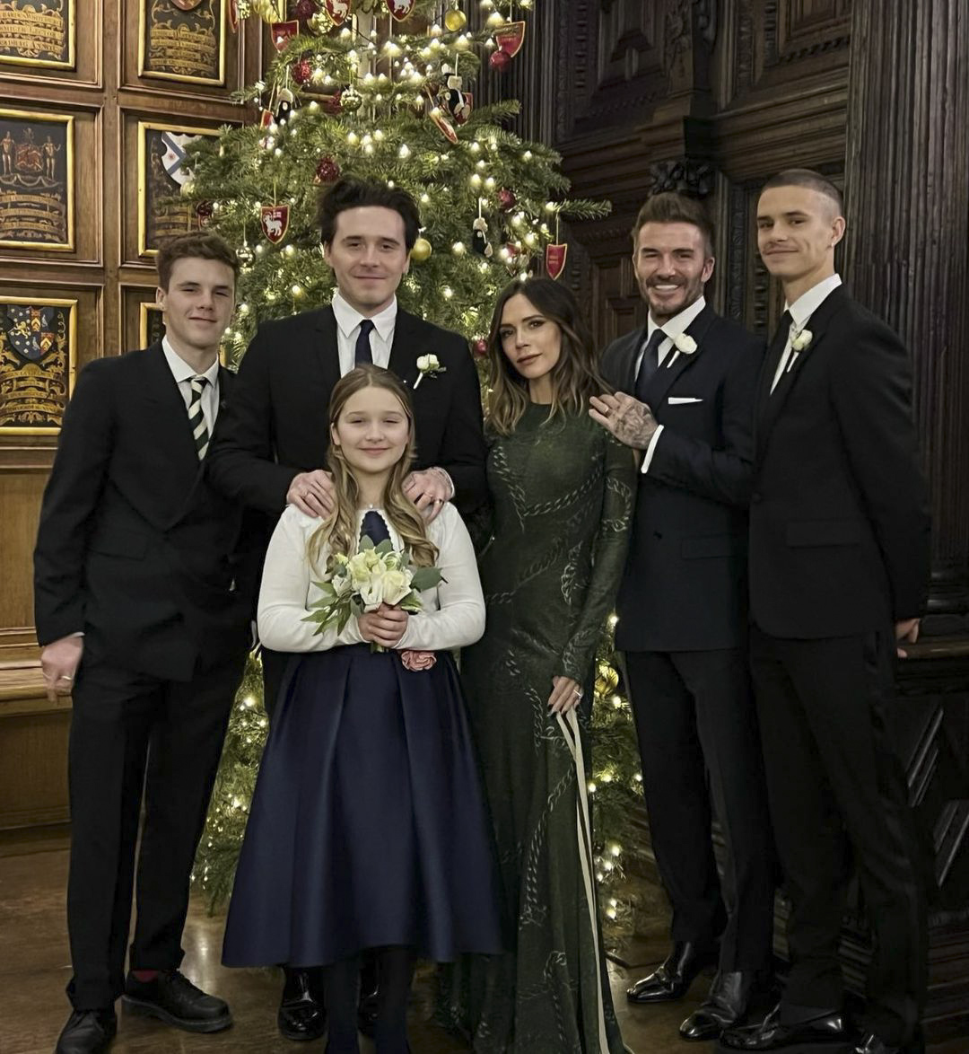 The Beckham family, including David, Victoria, Brooklyn, Romeo, Cruz, and Harper, pose in front of a Christmas tree.
