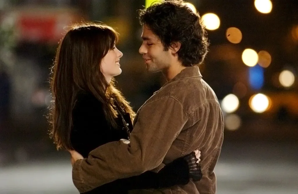 Anne Hathaway and Adrian Grenier face to face in an embrace.