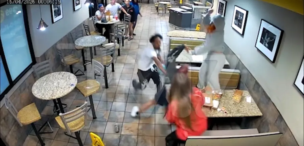 Video still of a chaotic scene inside a fast-food restaurant with people fighting.