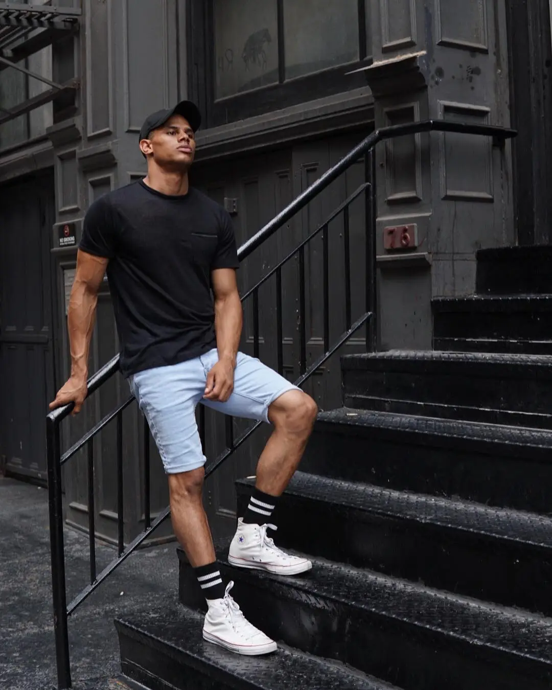 Donovan Michaels posing on a dark metal staircase outside a building.