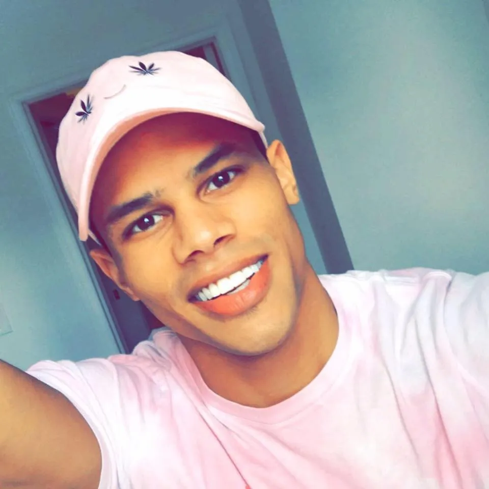 Donovan Michaels smiling while wearing a pink baseball cap and pink t-shirt.