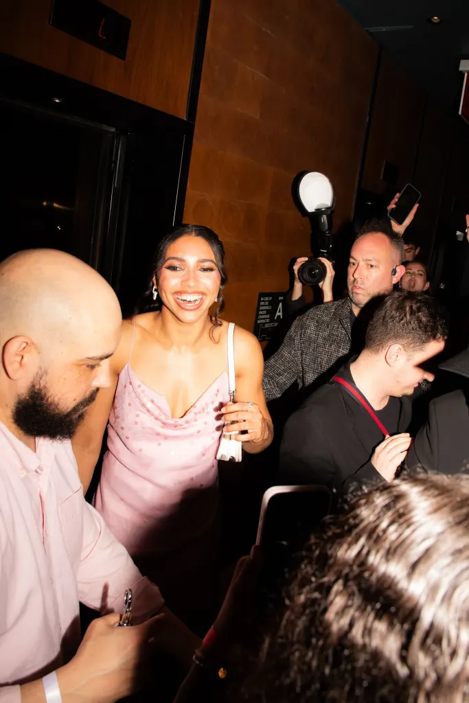 Azzi Fudd smiling, surrounded by a crowd and photographers at her "electric" party.