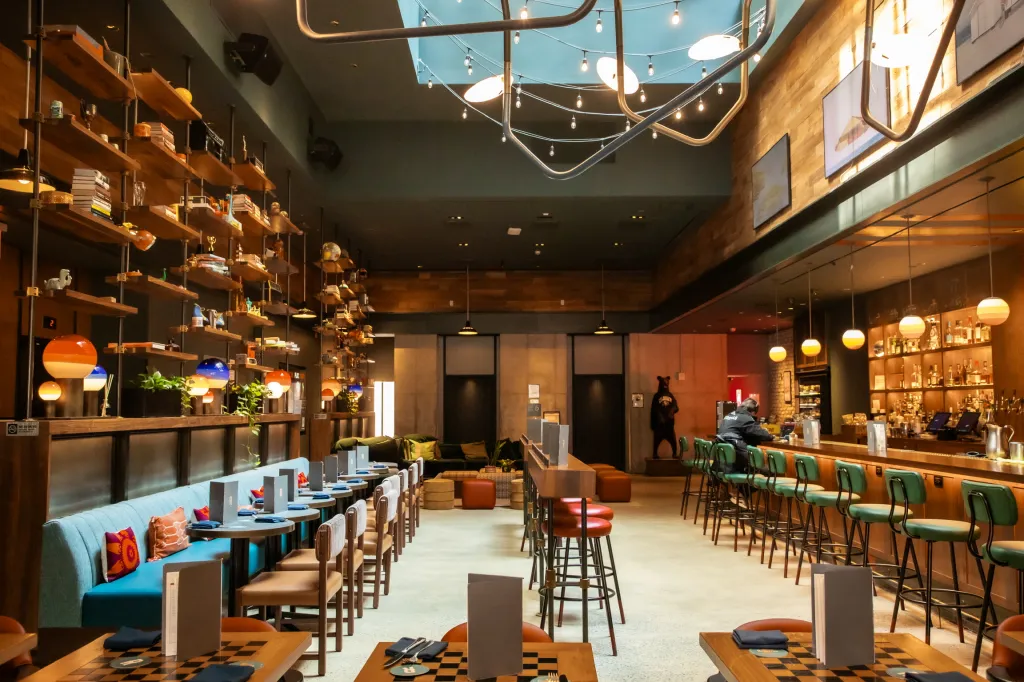 Interior of a restaurant with a bar area, booth seating, and shelves filled with decorative items.