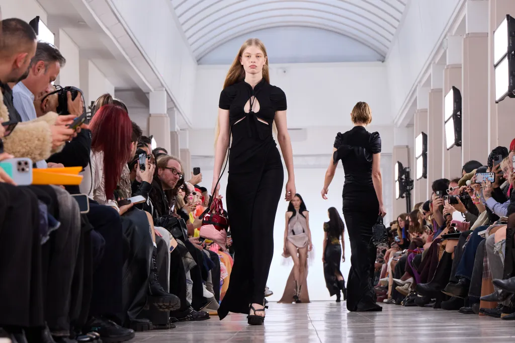 Vivian Jenna Wilson models a black cut-out dress and a red and pink handbag at the Ottolinger Spring/Summer 2026 runway show.