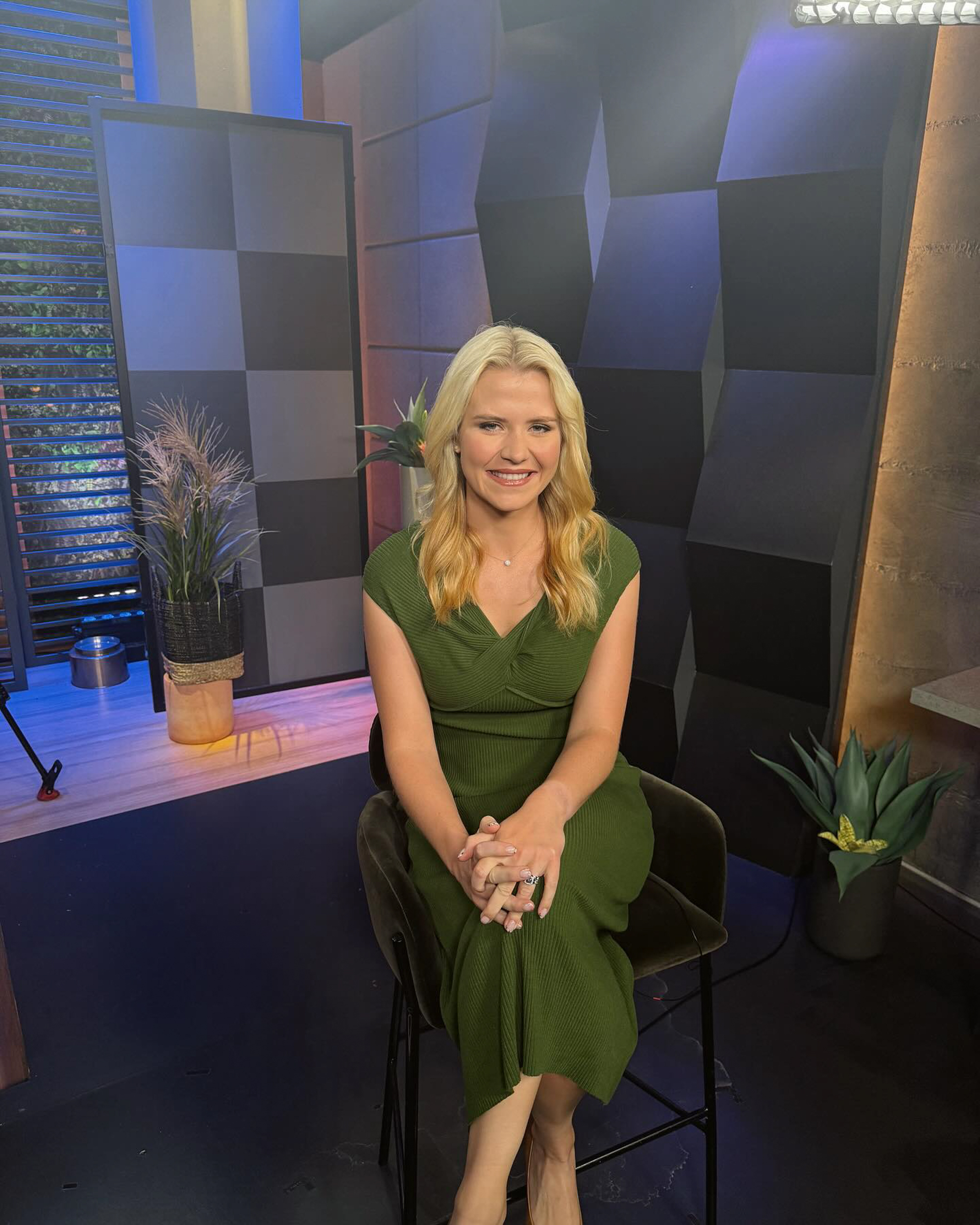Elizabeth Smart smiling and sitting in a green dress.