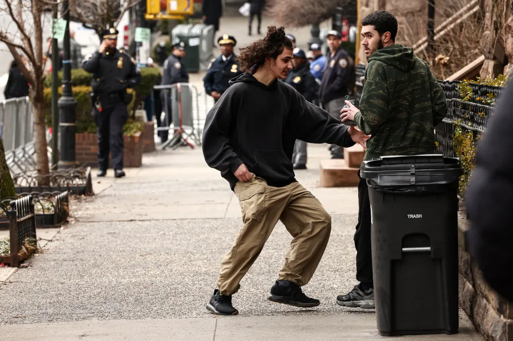Emir Balat receives a homemade explosive device from Ibrahim Kayumi during a protest in New York.