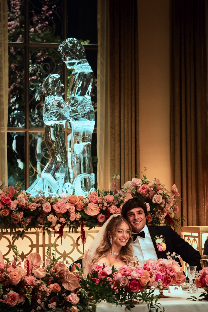 Sydney Sweeney and Jacob Elordi as Cassie and Nate in "Euphoria" at a wedding reception, with a large ice sculpture behind them.