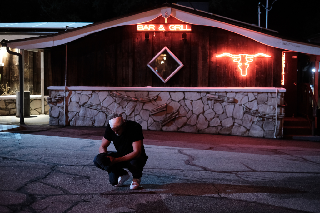 Eric Dane as Cal Jacobs crouching outside a Bar & Grill.