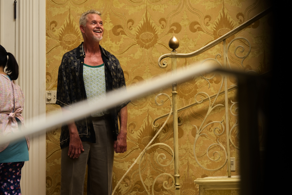 Eric Dane as Cal Jacobs in a printed shirt and patterned tank top, smiling in front of a golden patterned wallpaper.