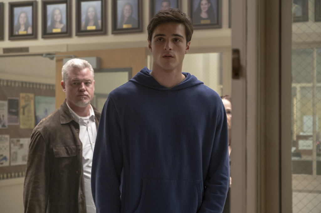 Jacob Elordi as Nate Jacobs in a blue hoodie, with Eric Dane as Cal Jacobs standing behind him.