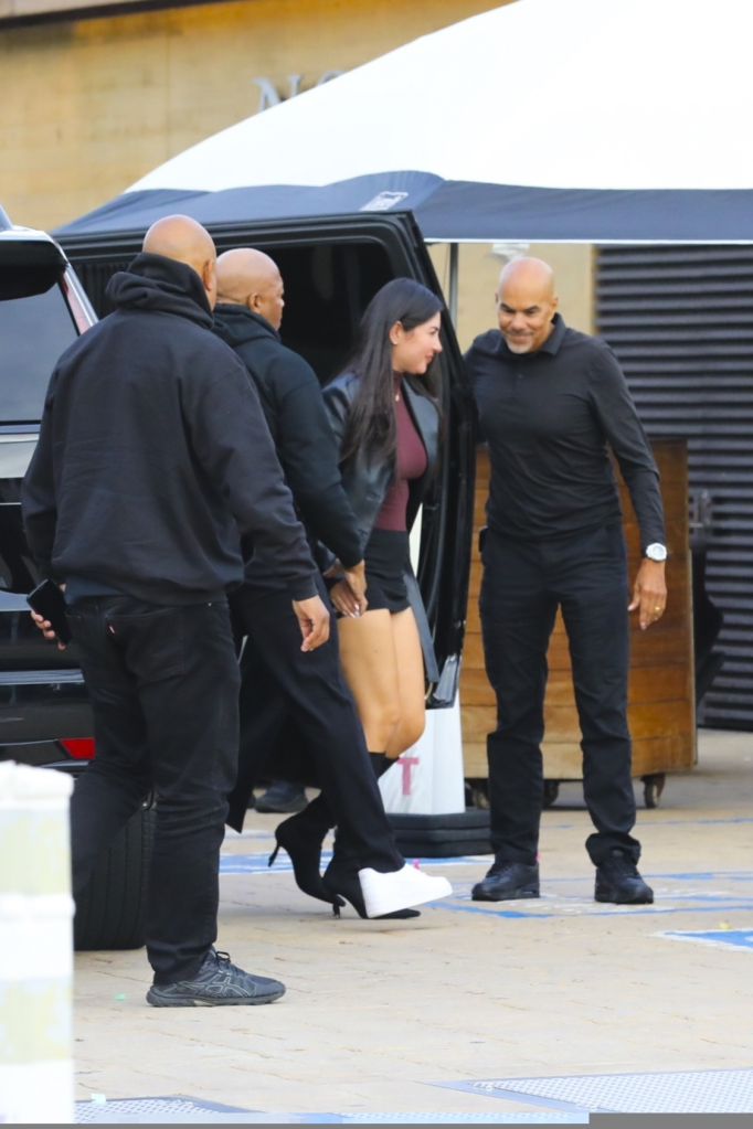 Dr. Dre exiting Nobu restaurant with a woman and several bodyguards.