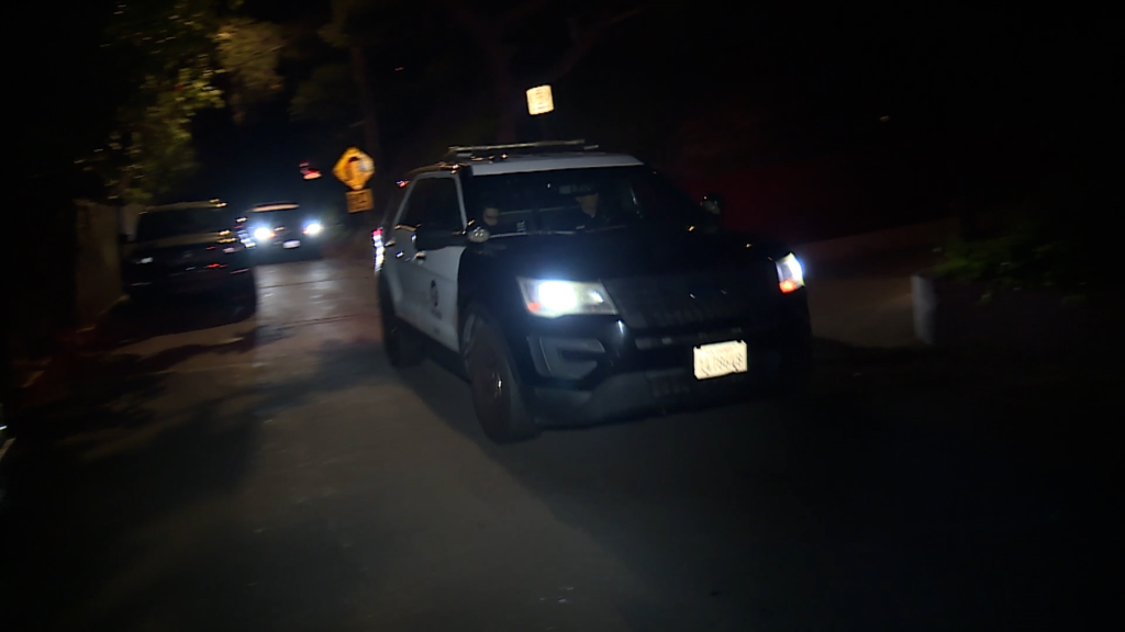 A police car at night with headlights on.