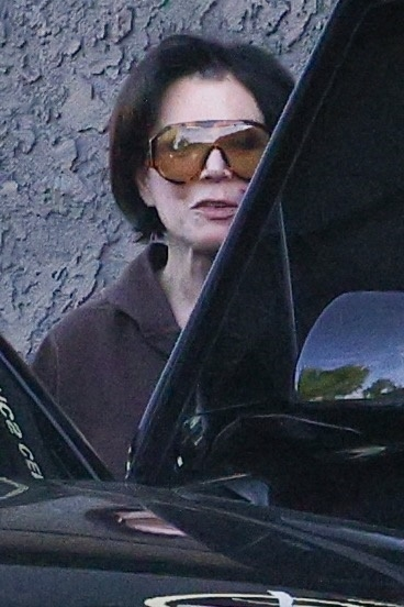 Kris Jenner, wearing large orange sunglasses and a brown top, leaving a spa.