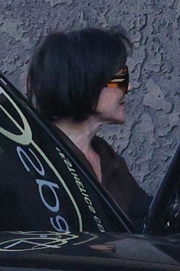 Kris Jenner in profile, wearing large sunglasses, after a face treatment.