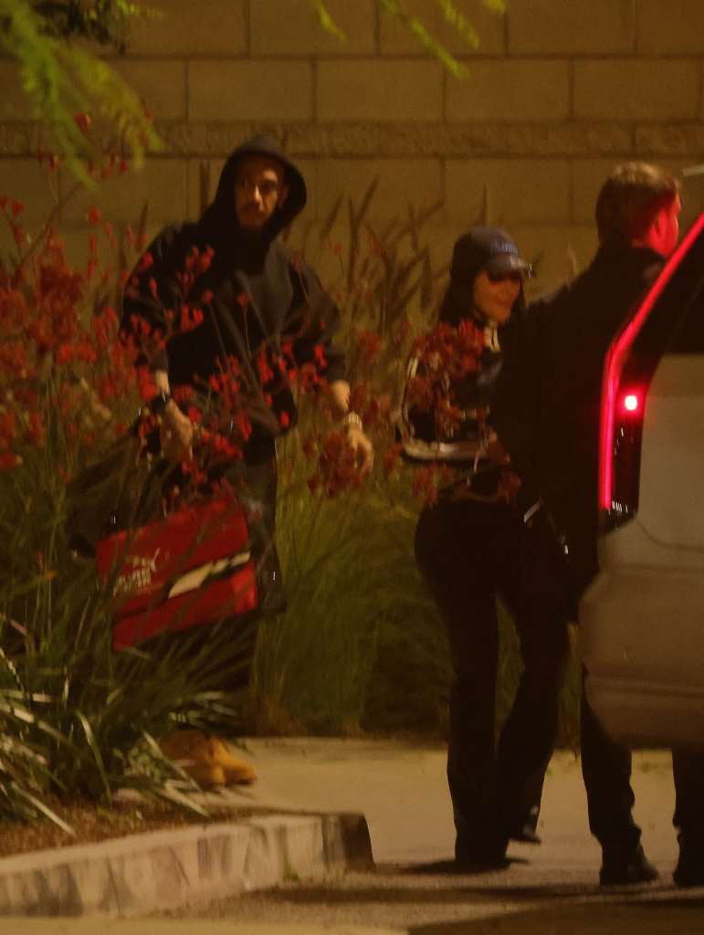 Kim Kardashian and Lewis Hamilton getting out of a car at night.