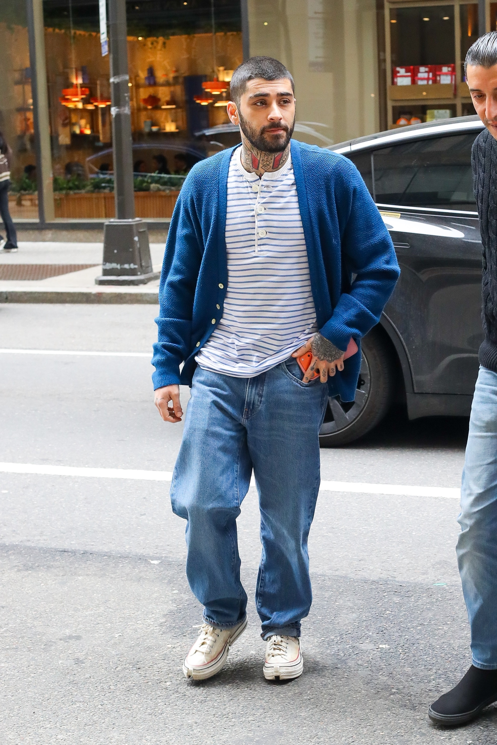 Zayn Malik in a blue cardigan and striped t-shirt walking in New York City.