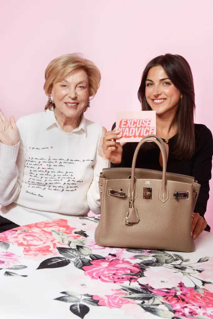 Kim Murstein and her grandmother Gail Murstein smiling for the "Excuse My Advice Podcast" with a Hermes Birkin bag.