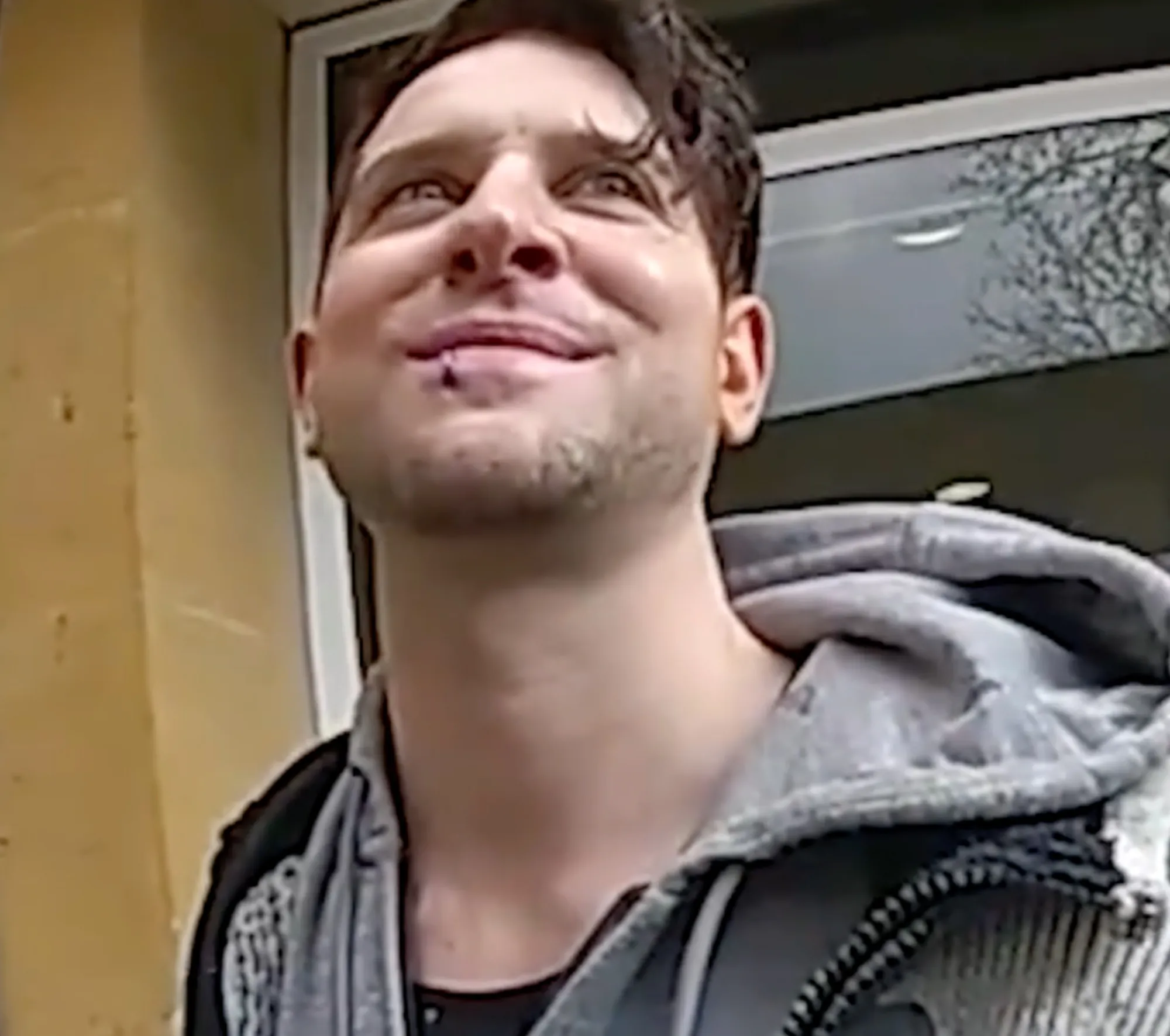 Ross Davidson smiling, wearing a gray hooded sweatshirt.