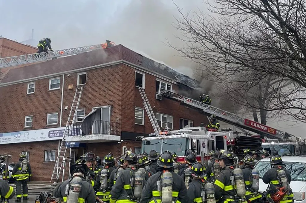 Firefighters battling a four-alarm fire at a building in Queens.