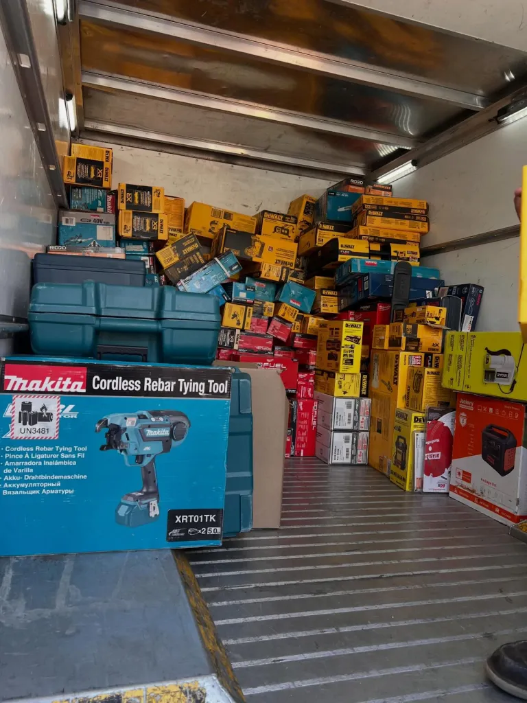 Boxes of stolen tools, including brands like Makita and DeWalt, piled high in the back of a truck.