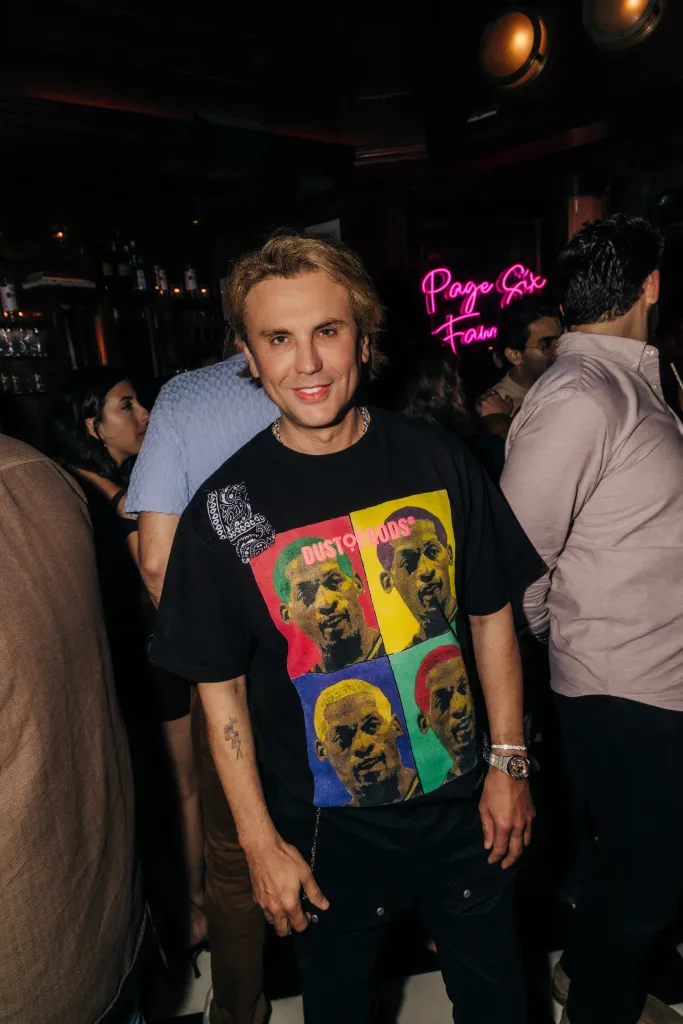 FoodGod Jonathan Cheban smiles while wearing a colorful t-shirt with four images of Dennis Rodman.