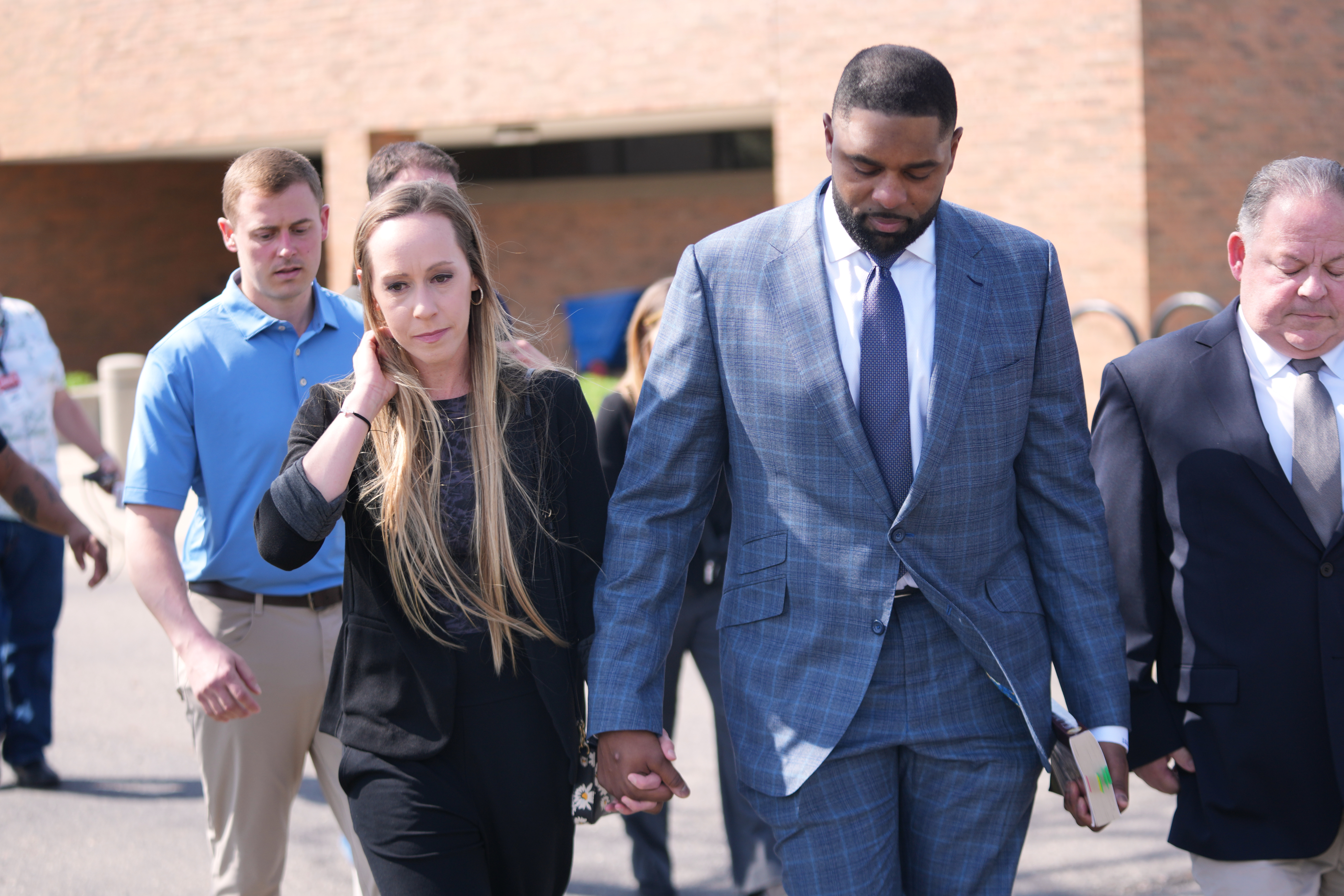 Sherrone Moore and his wife Kelli leave court