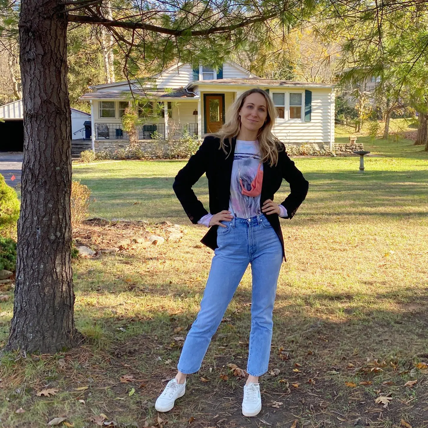 Nikki Glaser standing in front of her childhood home.