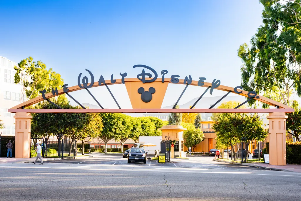 The entrance to The Walt Disney Studios in Burbank, California, featuring a large archway sign with the Walt Disney Co. logo and Mickey Mouse silhouette.
