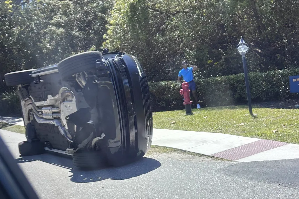 Tiger Woods stands near his overturned vehicle.