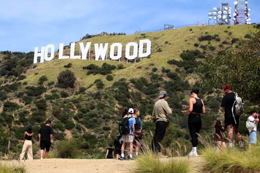 People hiking on trails below the Hollywood sign in Los Angeles.